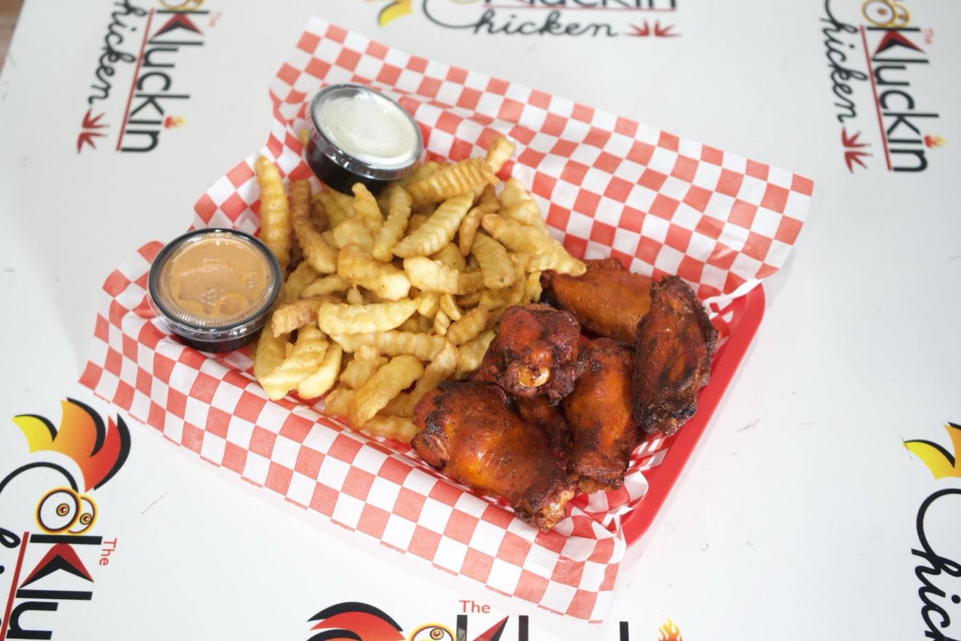 A Kluckin combo of chicken and fries on checkered paper